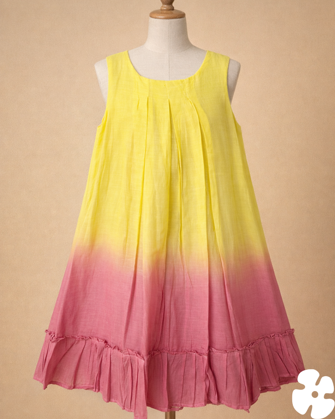 Yellow to pink gradient dress on a mannequin against a beige background